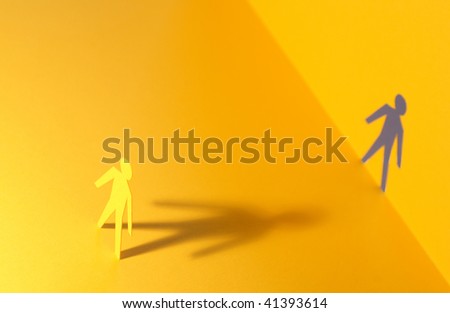Paper man standing against his outline cutting in paper wall