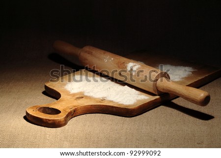 Wooden rolling pin and flour on cutting board