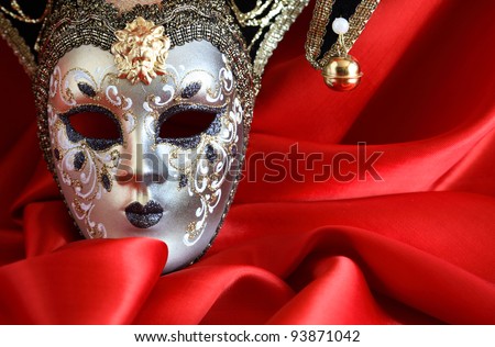 Closeup of classical venetian mask on red silk background with free space for text