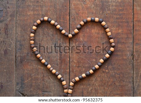 Costume Jewelry. Heart shape made from wooden necklace on wood surface
