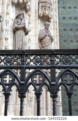 Closeup of nice wrought fence against Seville Cathedral, Spain