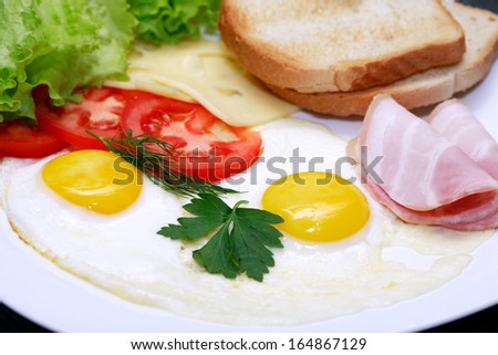 Closeup of plate with fried eggs, toasts and cheese