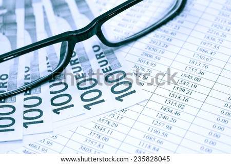 Financial background. European Union Currency near spectacles on paper background with digits table