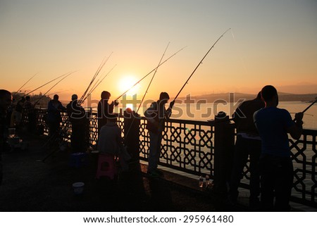 Istanbul, Turkey - July 5, 2015: People fishing at dawn on Galata Bridge in Istanbul