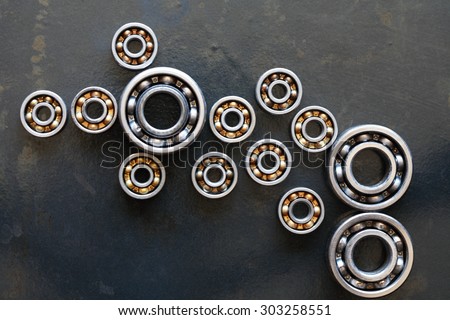 Machinery concept. Set of few ball bearings on dark metal background