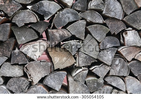 Closeup of gray dry fire-wood. Farm background