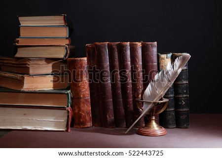 Vintage library. Feather against set of old books in a row