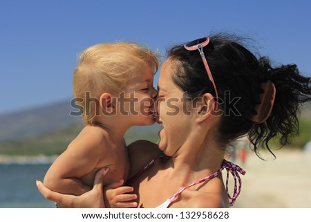 baby biting her mother\'s nose