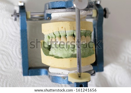 dental technician completes the process of making ceramic teeth in dental lab. Glaze.