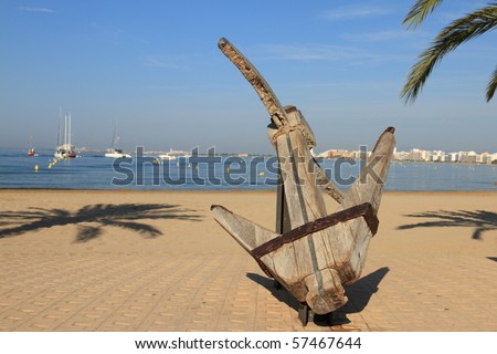 view of a beach of spain (rosas in costa brava) with an anchor in the foreground