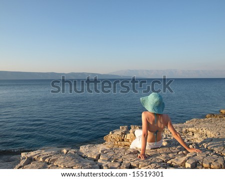 Woman taking in the beauty of the view. She is wearing linen pants and straw hat. Adriatic islands, Croatia.