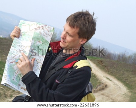 Young man reading map during spring excursion.