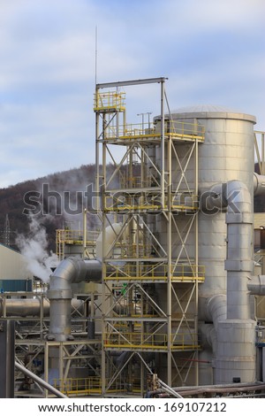 Chemical factory structures with tanks, pipelines, chimney. Vertical, nobody