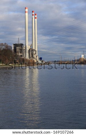Power plant industry along the river with tall chimney, water reflections. Landscape, nobody