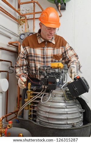Service Man Working on Furnace Model is actual electrician.