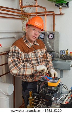 Service Man Working on Furnace Model is actual electrician.