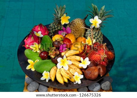 Tropical exotic fruits, Basket with exotic fruits from Bali Indonesia by the swimming pool