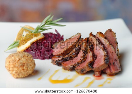 Duck breast fillet with red cabbage and potato ball.