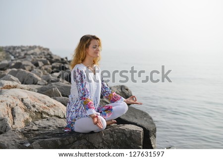 Meditation, Woman on rocky beach in yoga pose