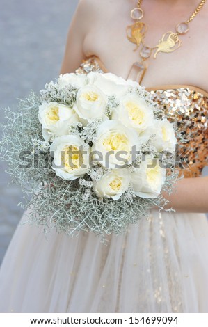 Bride holding wedding flower bouquet of white roses