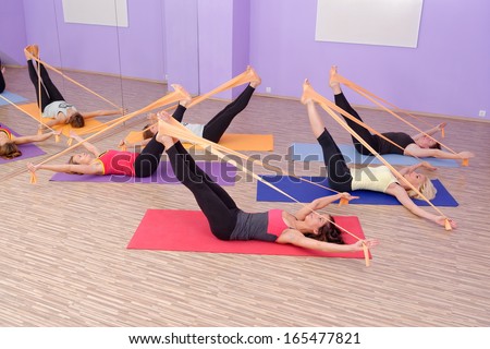 Aerobics HOT pilates group with rubber bands in a row at fitness gym