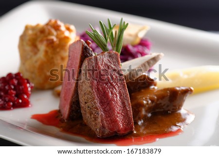 Venison meat steak with red cabbage, cranberries, herbs and Potato