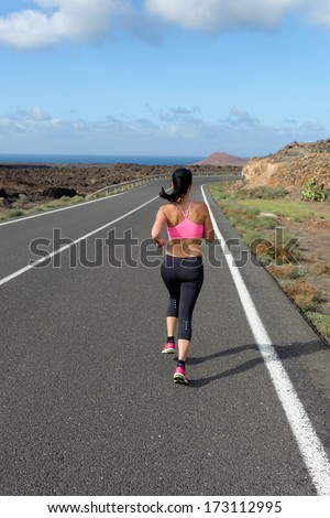 Runner woman running on mountain road in beautiful nature, volcanic landscape on Canary islands