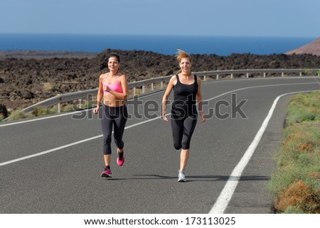 Two Runner women running on mountain road in beautiful nature, volcanic landscape on Canary islands