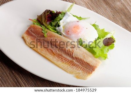 Steamed fish fillet with egg, salad and fresh herbs