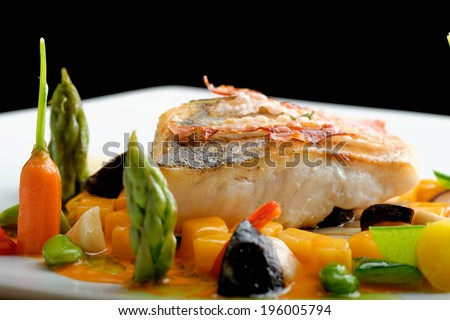 Fine dining, White fish fillet breaded in herbs and spice with grilled bacon and vegetables