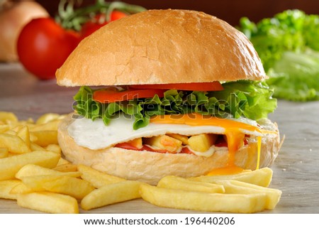 Big veggie burger with egg, fresh vegetables and french fries