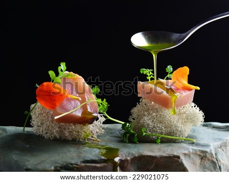 Fine dining, fresh raw ahi tuna sashimi served on sponge with herbs