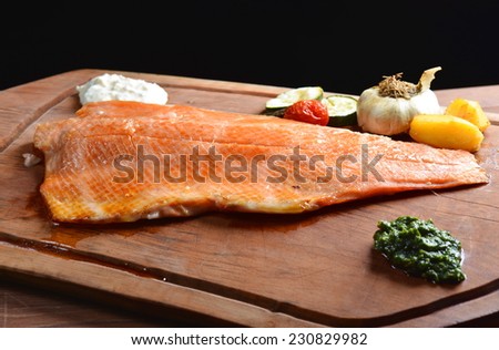 Smoked wild salmon fillet with vegetable on wooden board