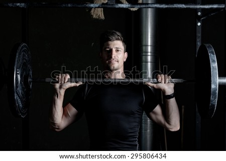 Athlete Fitness trainer working out / weight lifting in a gym