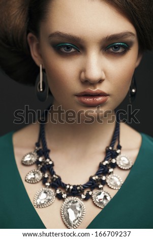 Beautiful young model with bright makeup and sunburn skin Evening make up, close up, green dress