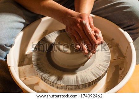 Hands working on pottery wheel , close up retro style