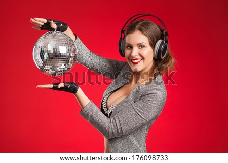 the girl the DJ in earphones. Red background. Musical accessories