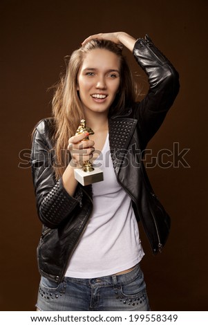 Beautiful girl holding a statuette. Reward. Vivid emotions, actress