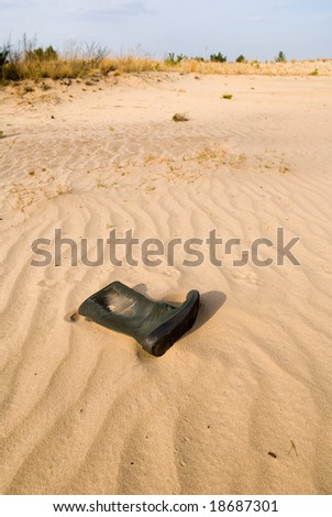 old knee-boot on sand