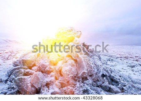 frozen heap of rocks in a rays of sun