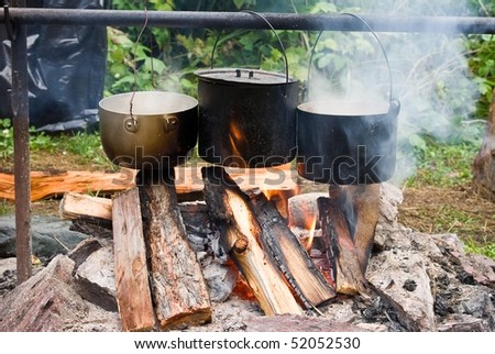 three touristic cauldron in a campfire