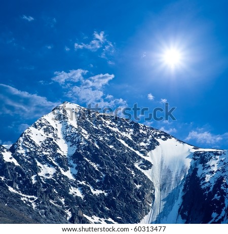 snowbound mountain peak under a sparkle sun
