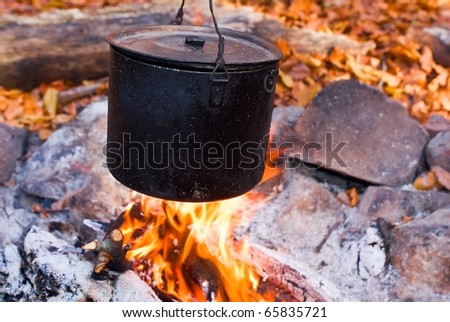 black touristic cauldron in a campfire