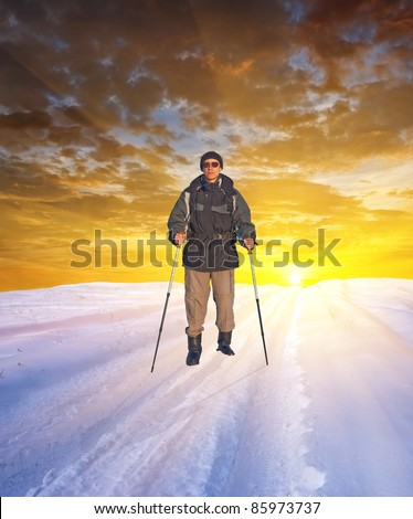 hiker in a winter plain by a sunset