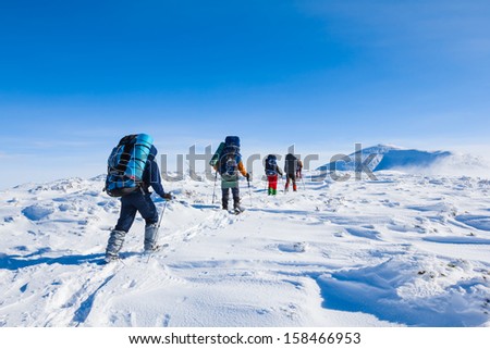 group of tourists walking among a winter plain