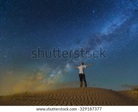alone man under a night sky in a desert