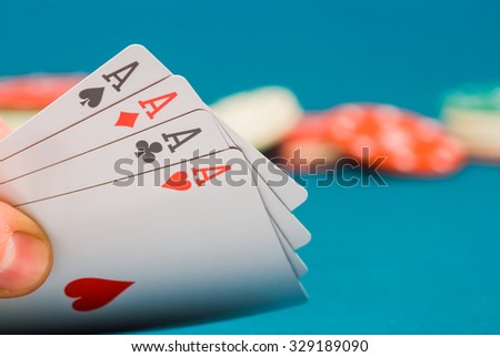 playing cards in a hand on a green felt