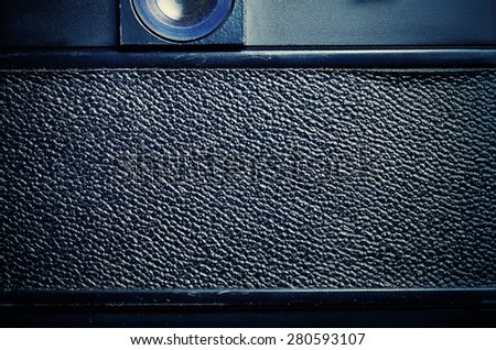 Back part of the film dslr camera with a cover the covered skin. Close-up view. Macro. Vintage photo. Toning.