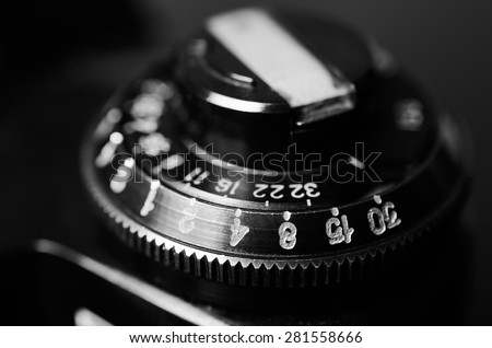 Old film DSLR camera. The dial sensitivity of the film. Rewinding the film. Close up view. Macro. Selective focus. Vintage photo. Black and white.