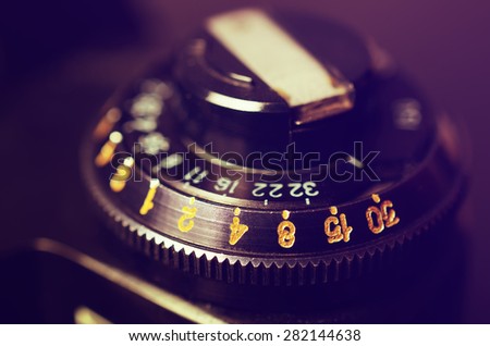 Old film DSLR camera. The dial sensitivity of the film. Rewinding the film. Close up view. Macro. Selective focus. Vintage photo. Toning.